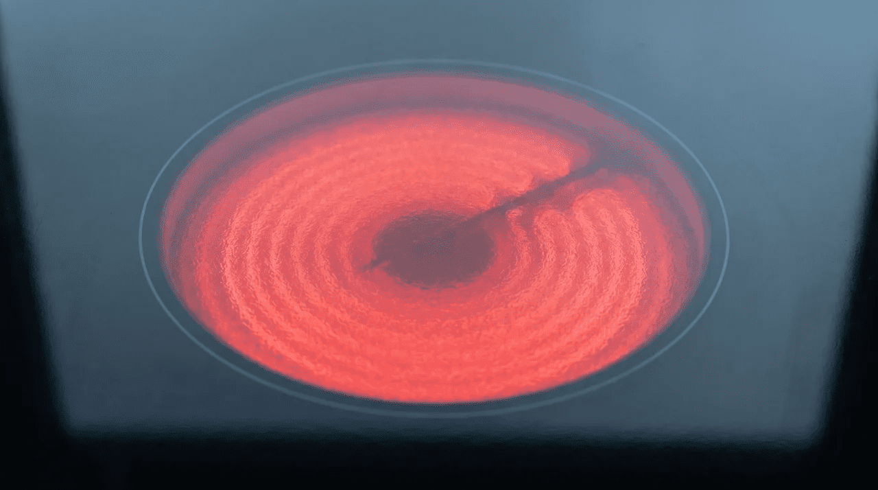 Ceramic hob glass surface with one cooking zone glowing red from the heating element beneath
