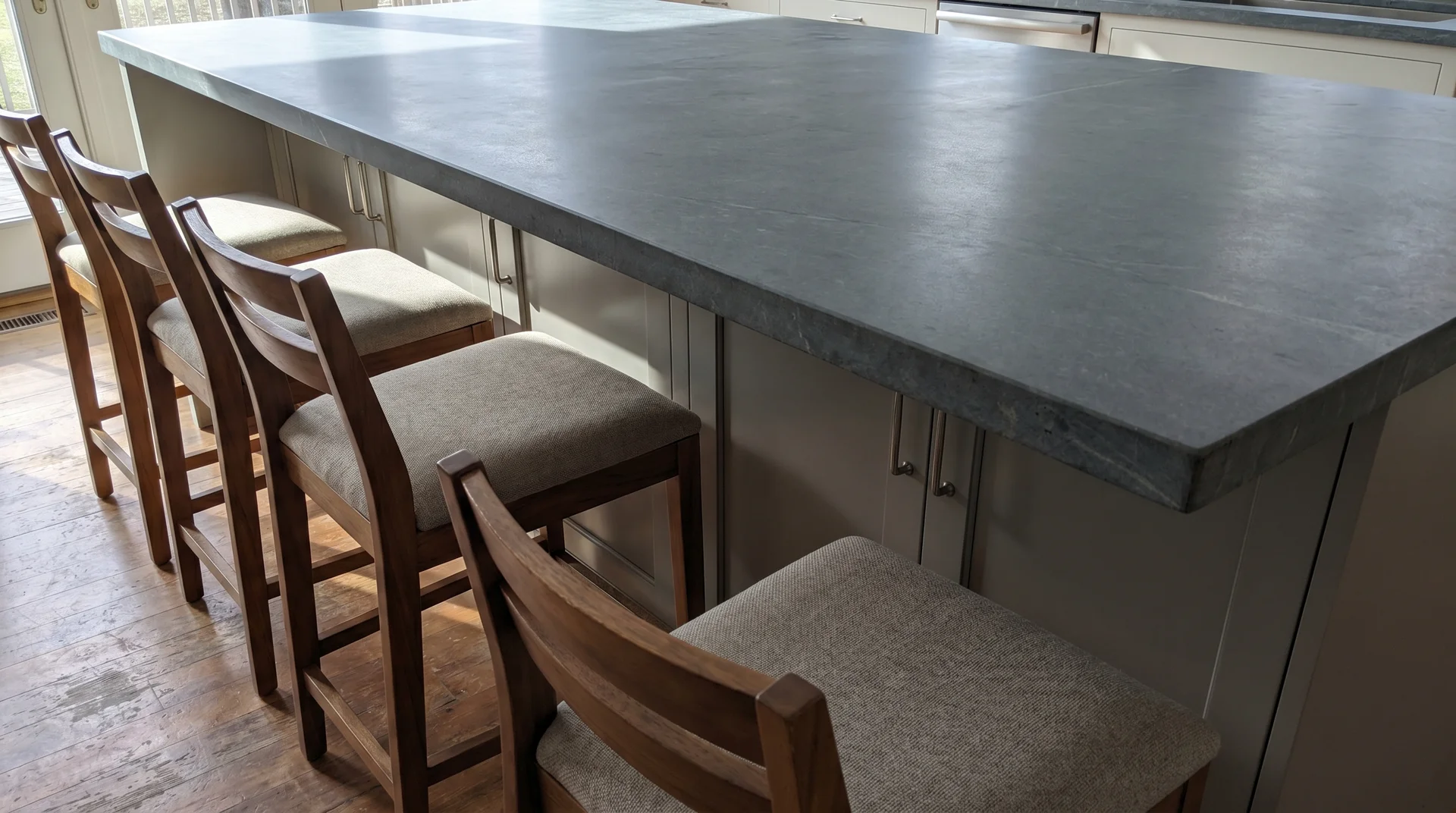 Counter-height kitchen island with three stools showing overhang depth and seating clearance