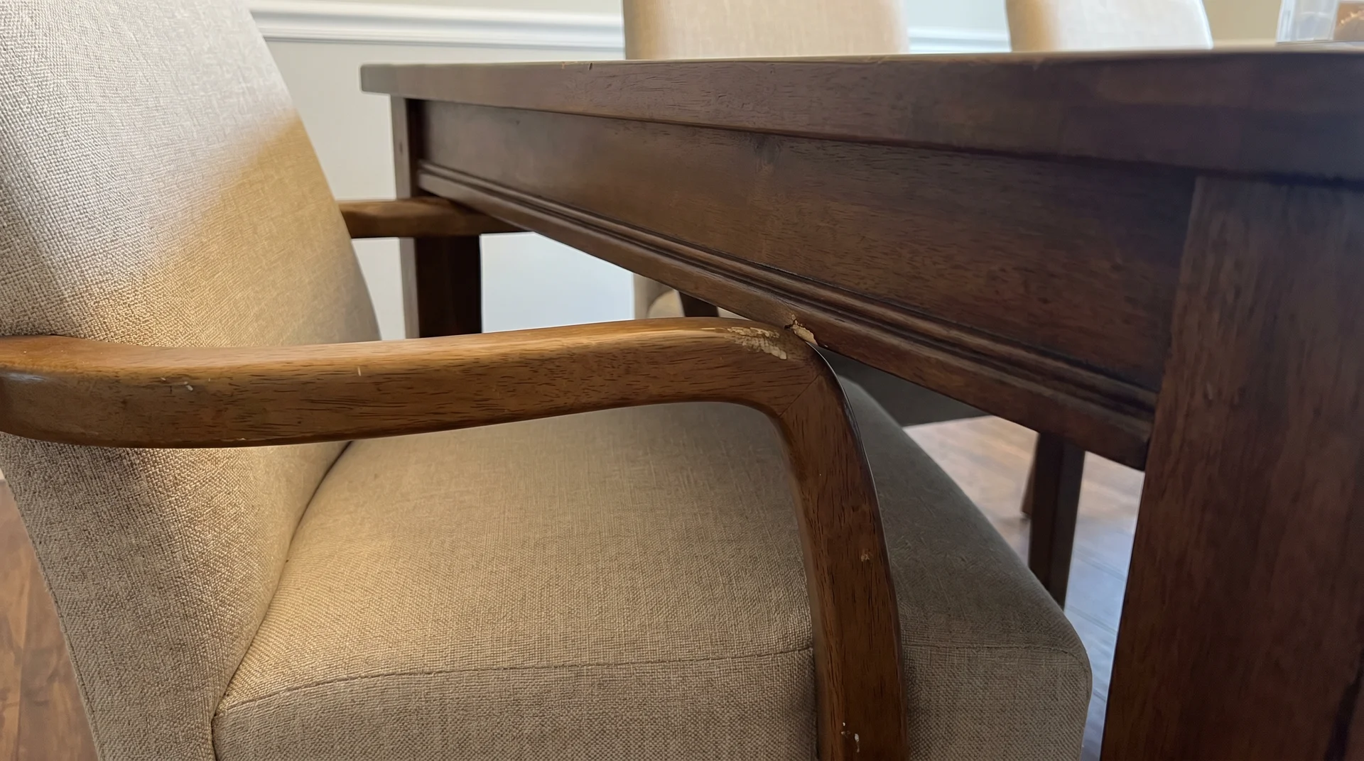 Dining chair armrests blocked by table apron rail, unable to push chair under table
