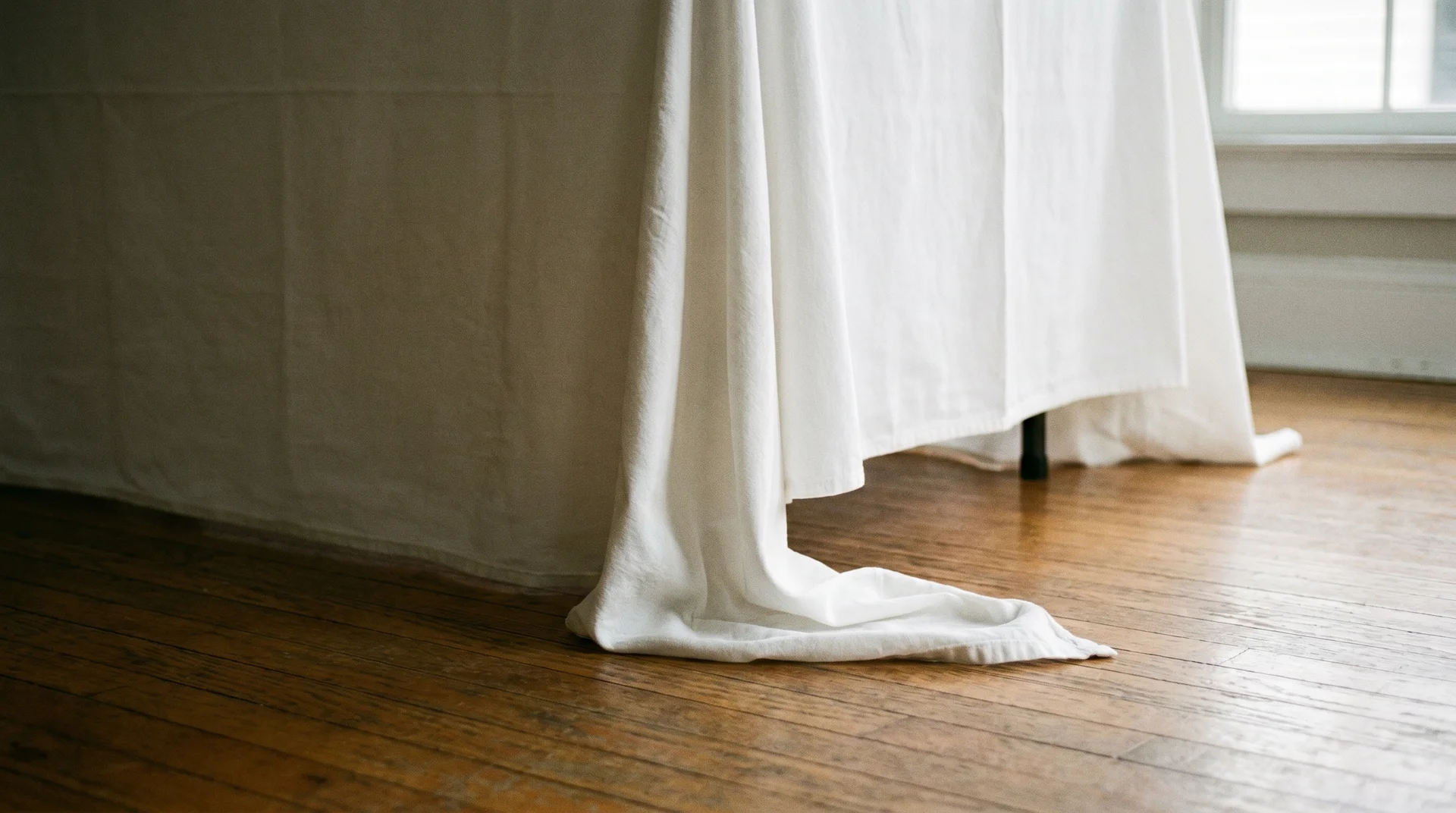 Floor-length tablecloth hem resting at floor level on a standard folding table
