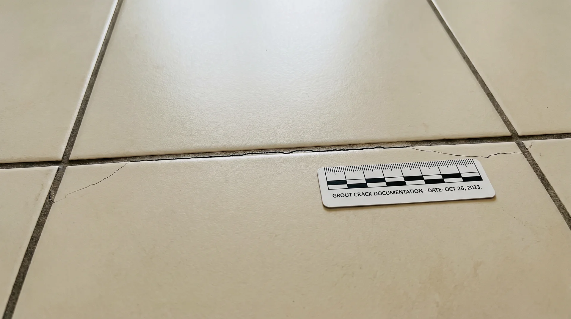 Hairline cracks along grout lines caused by premature grouting over uncured thinset