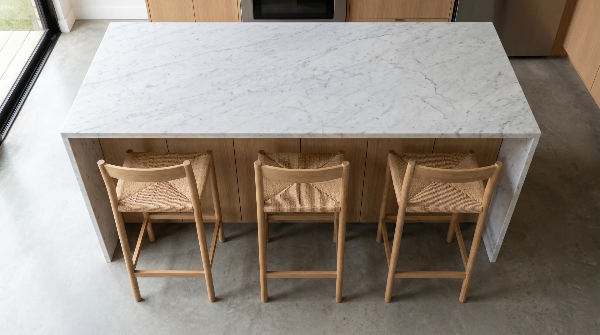 Overhead view of kitchen island with three evenly spaced stools demonstrating 24-inch per-seat spacing
