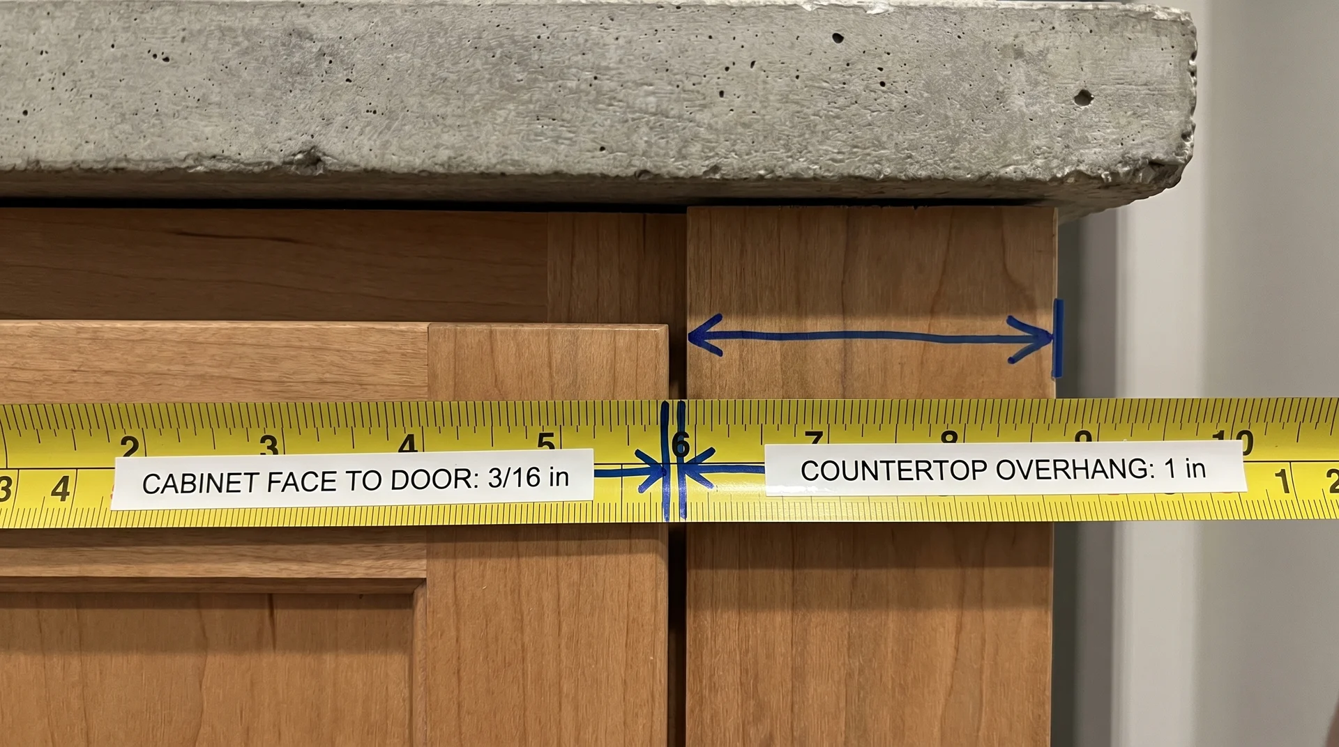 Tape measure showing cabinet box depth, door face, and countertop overhang as separate measurements
