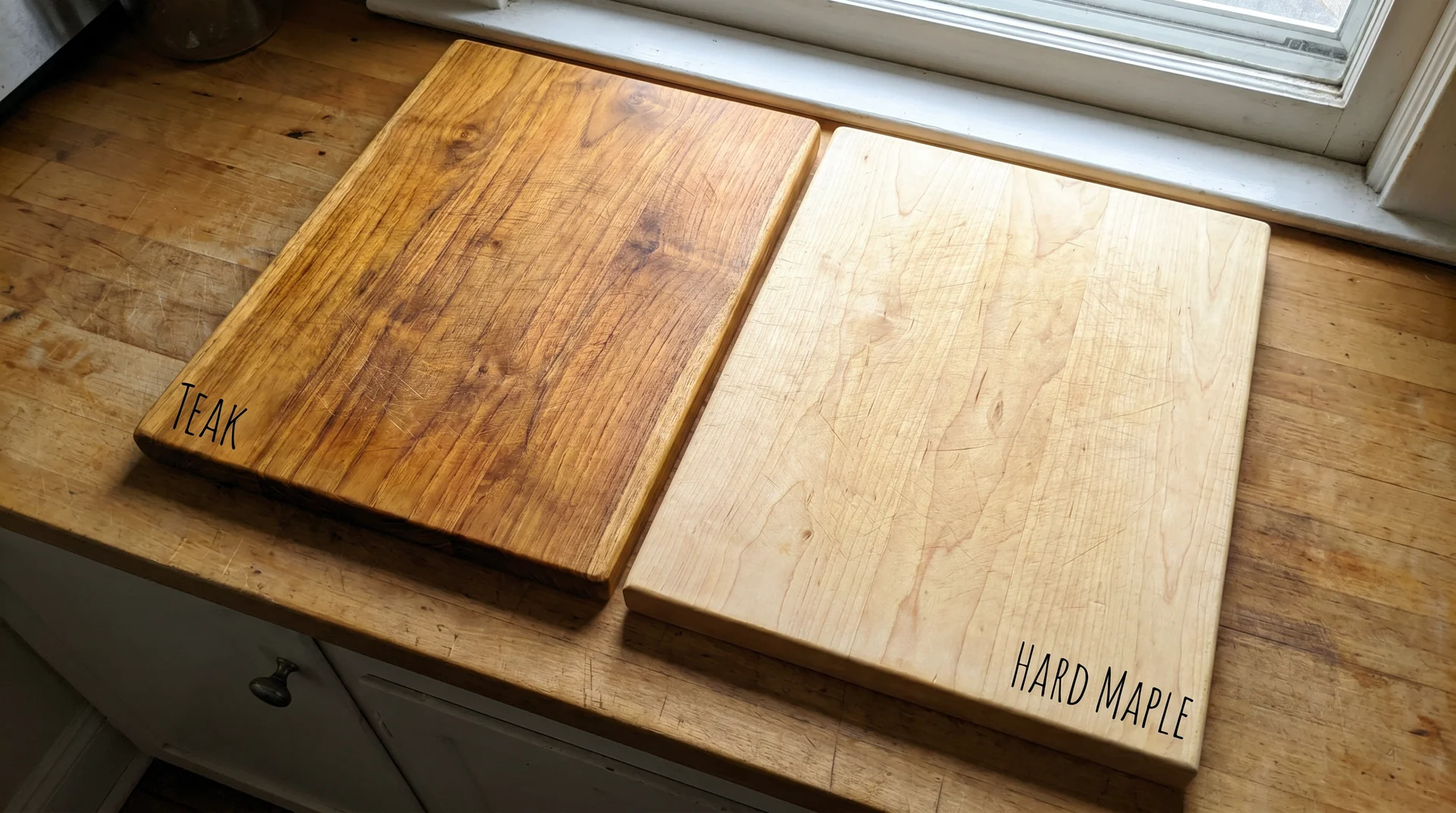 Teak cutting board next to hard maple cutting board showing color and grain comparison