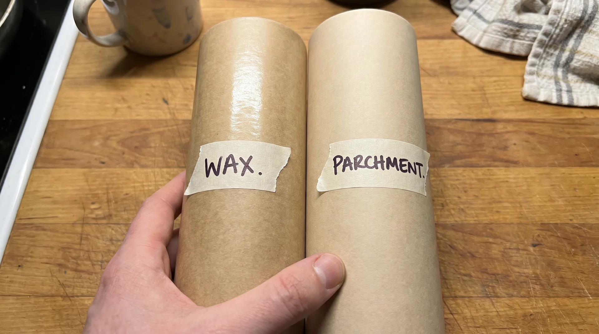 Wax paper and parchment paper rolls side by side showing similar appearance with handwritten labels distinguishing them