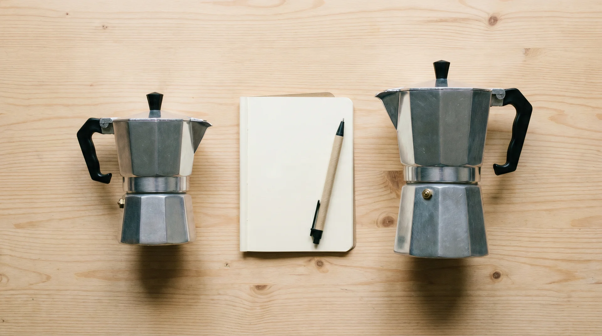 3-cup and 6-cup moka pots beside a notebook representing the size decision process