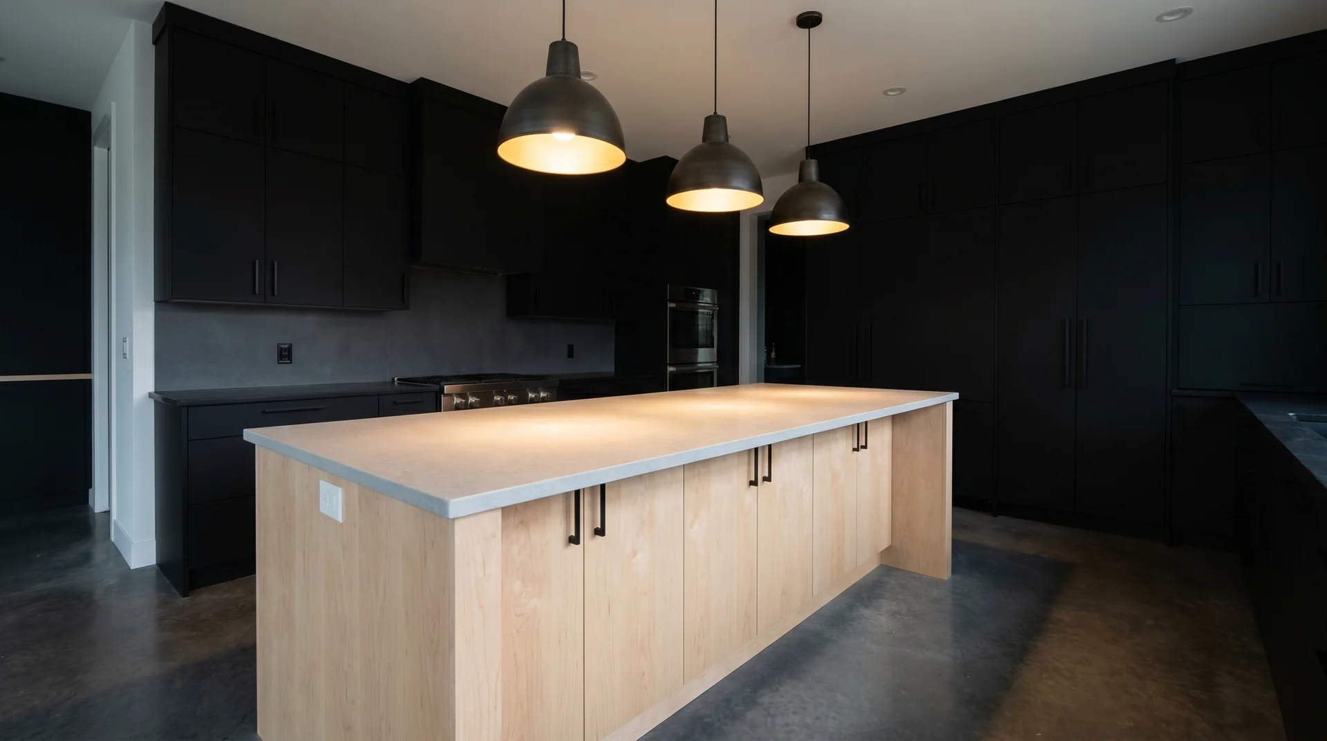 Black kitchen cabinets with a pale maple island, maximum material contrast, matte black hardware, overhead pendant light