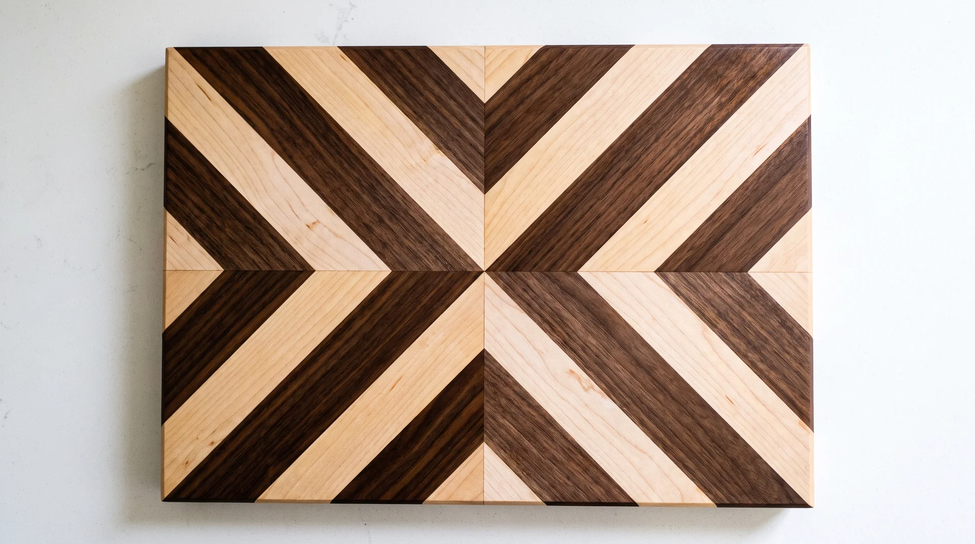 Face-grain chevron cutting board with walnut and maple strips forming a precise V at the center