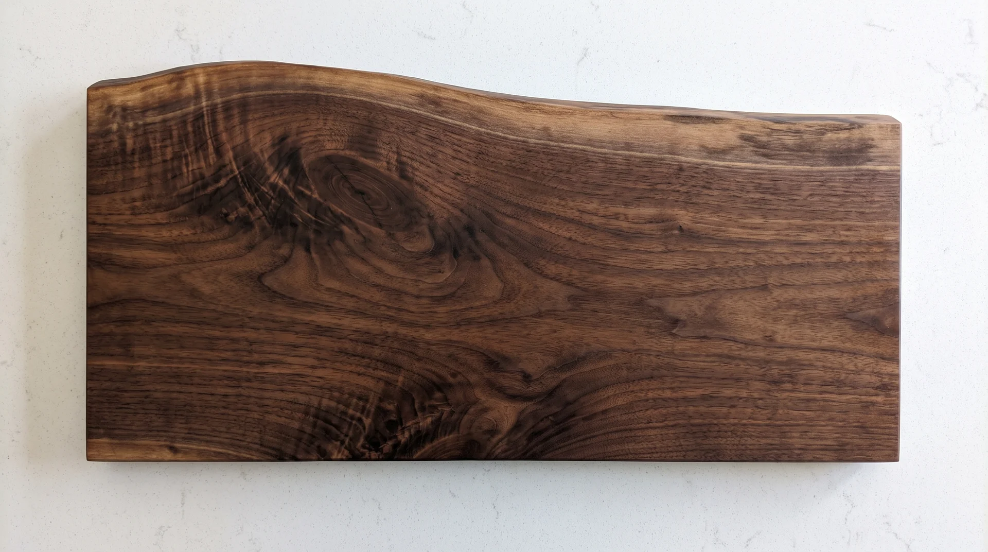 Live edge walnut board with natural tree silhouette on one side and straight edge opposite