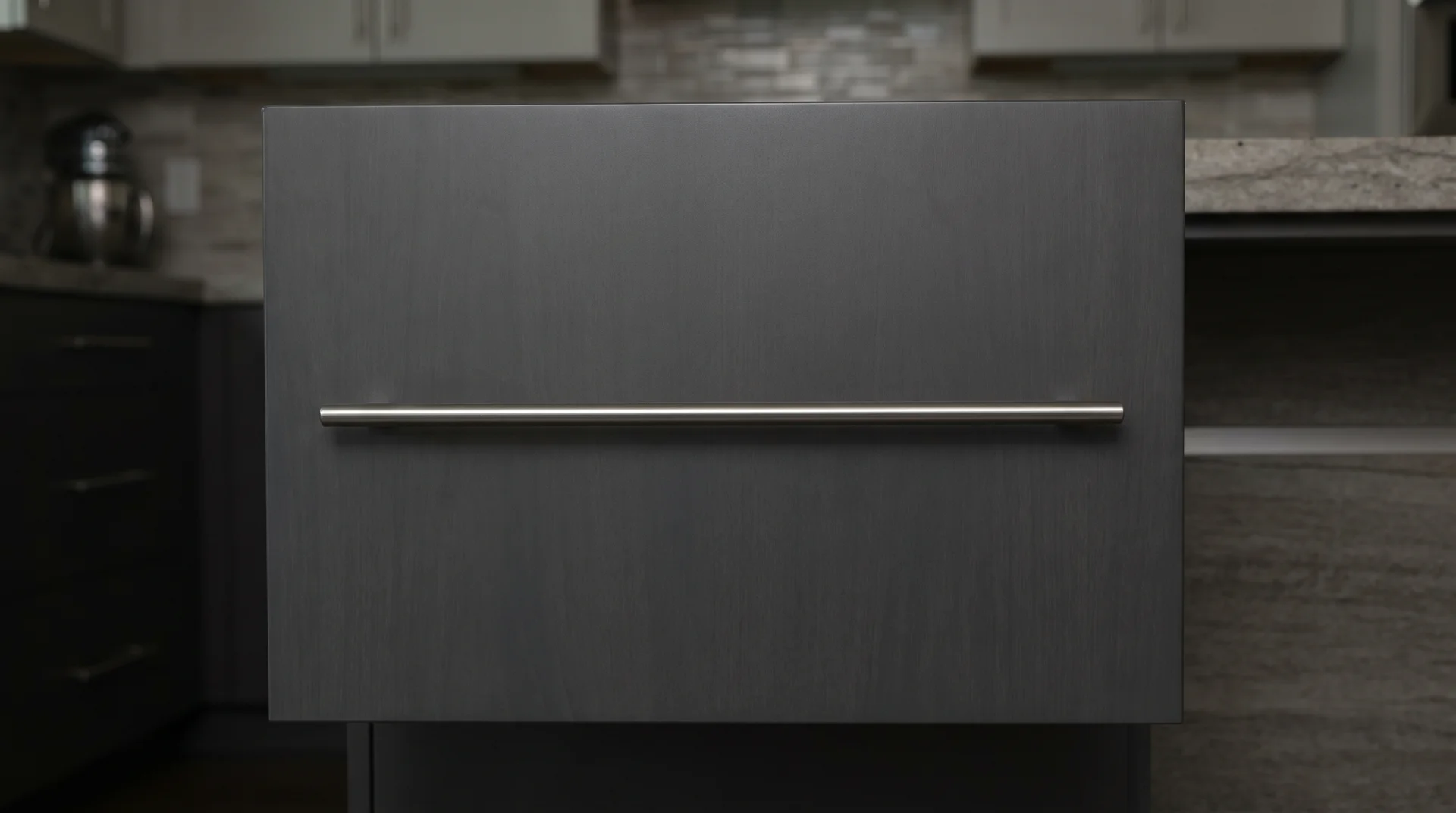Long bar pull on a flat-panel cabinet door showing hardware as the dominant visual element