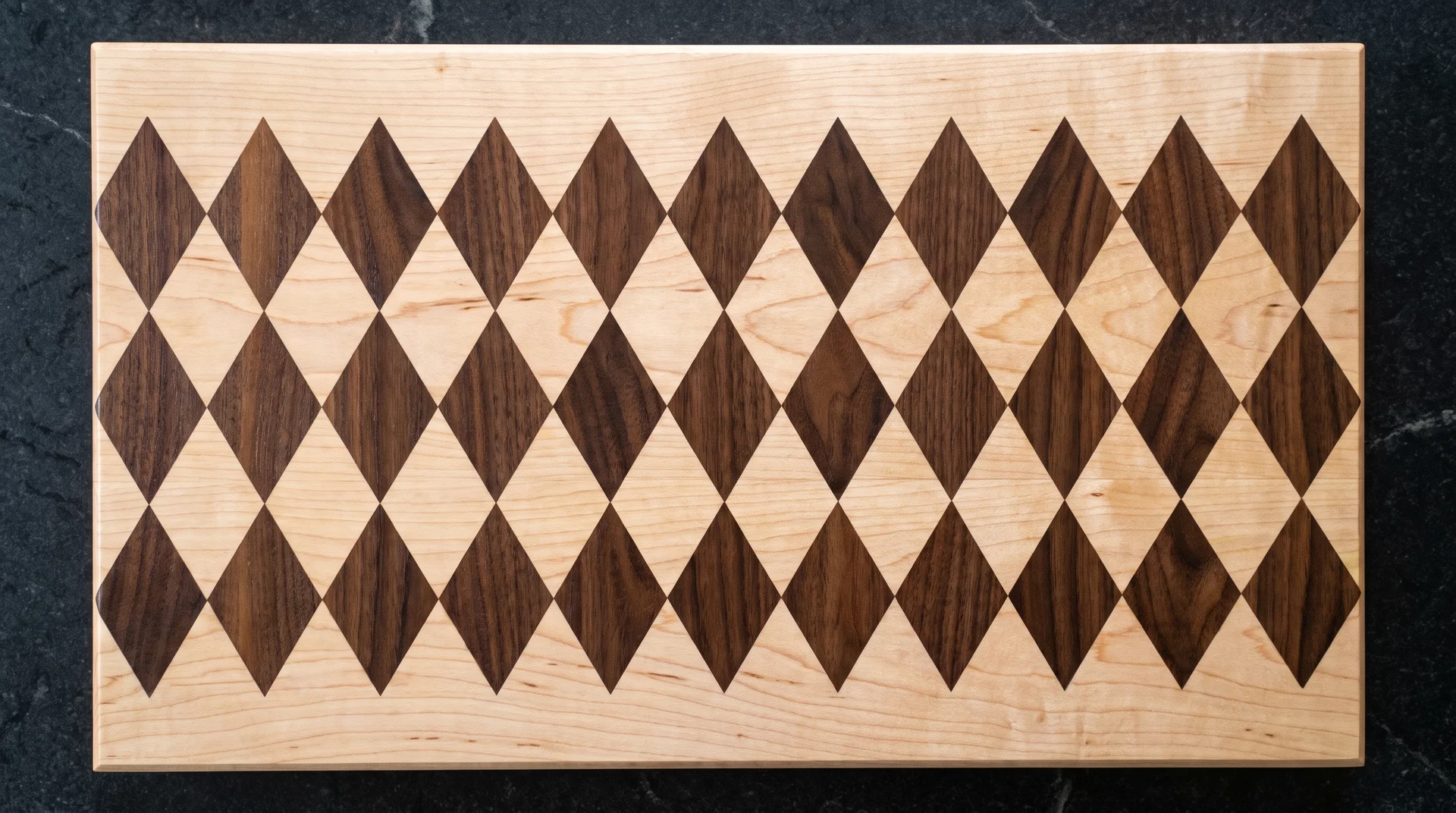 Maple cutting board with dark walnut diamond argyle inlays routed flush across the surface