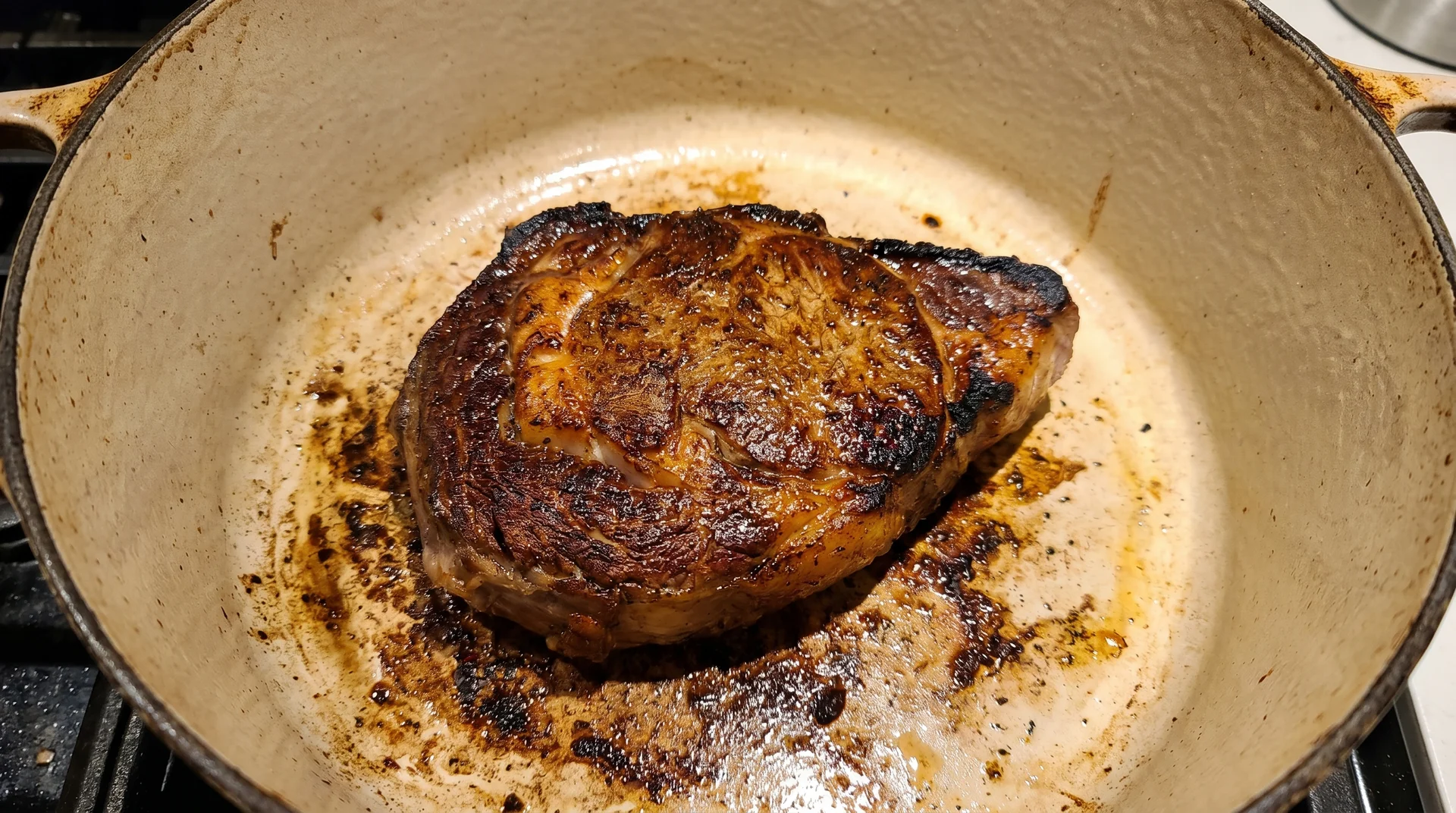 Seared beef with fond on the base of a Dutch oven before braising liquid is added
