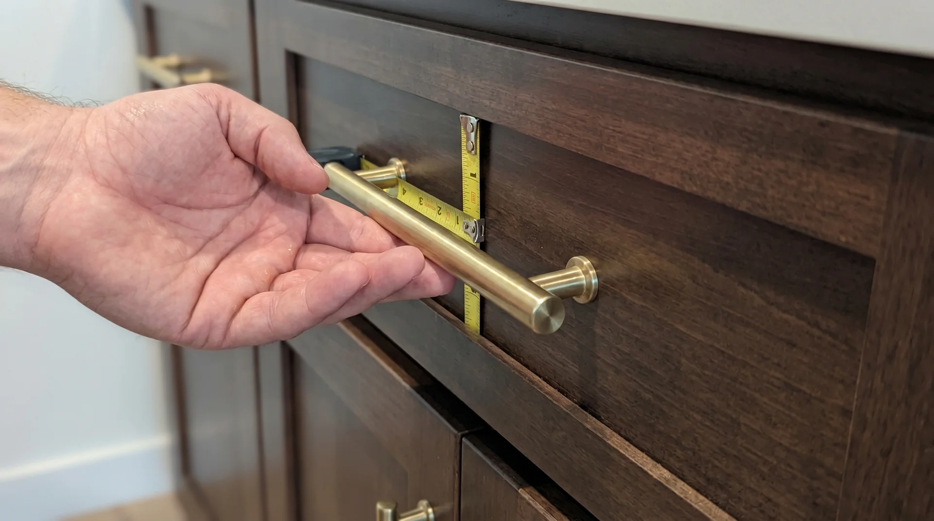 Side view of bar pull on base cabinet drawer showing projection gap between pull and cabinet face