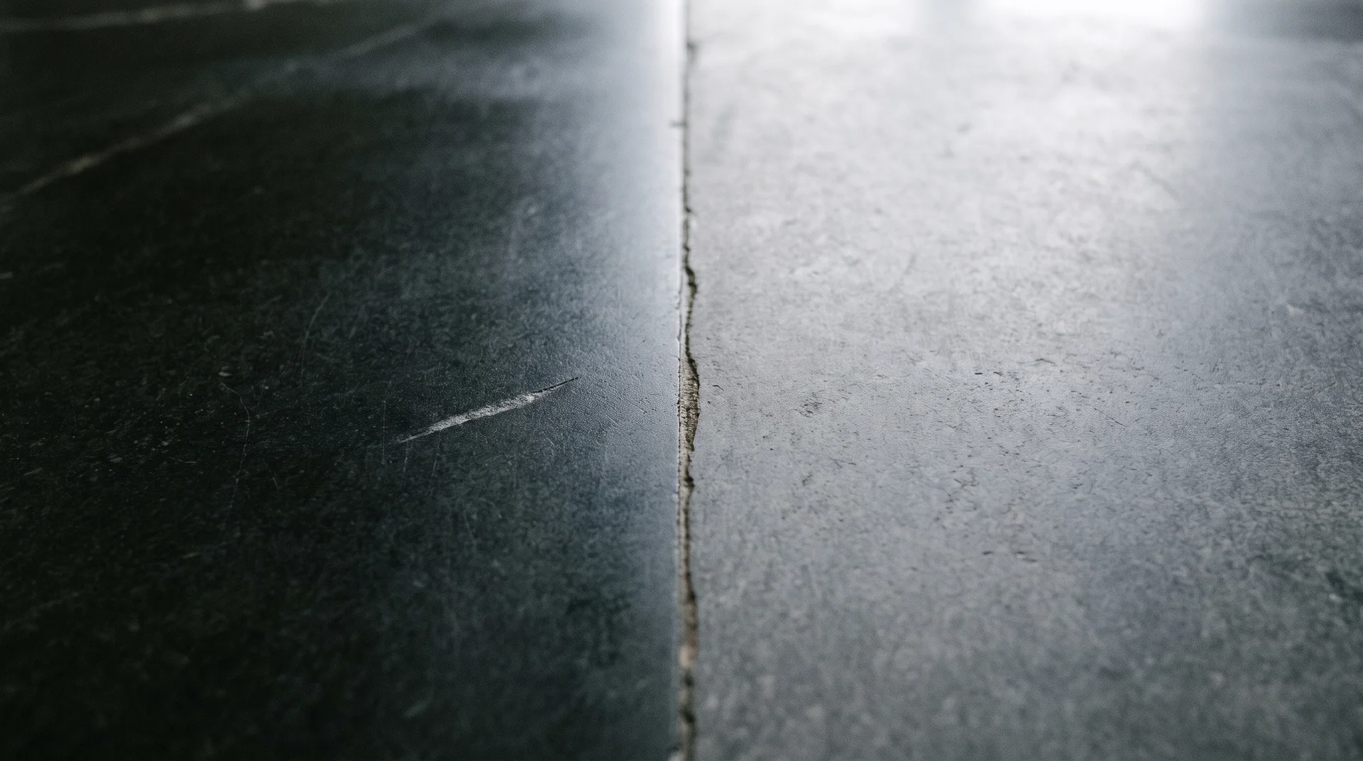 Soapstone island countertop showing the color difference between oiled dark charcoal and unsoaked lighter gray halves