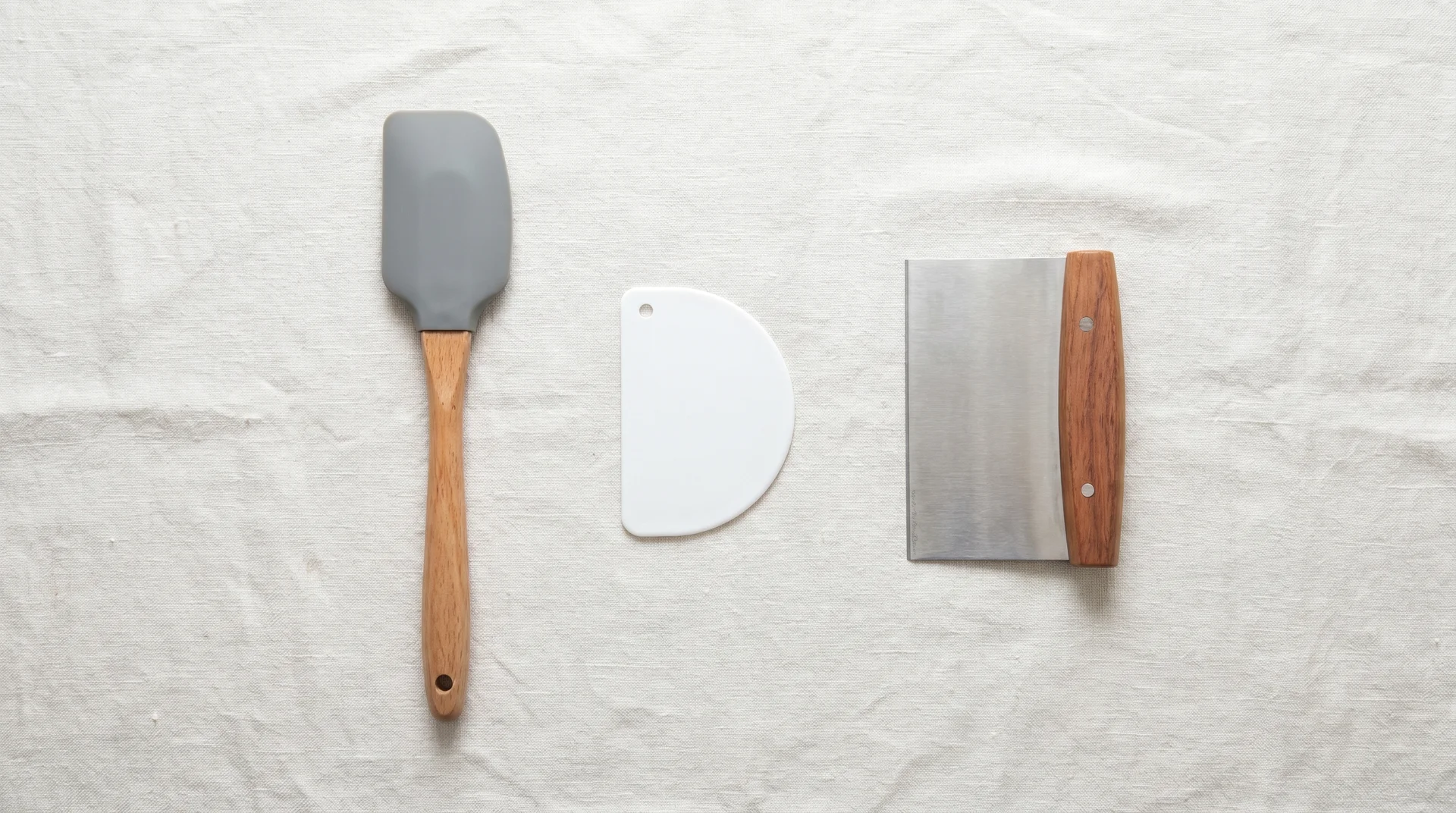 Three rubber scraper forms side by side: handled spatula scraper, handleless bowl scraper, and rigid bench scraper