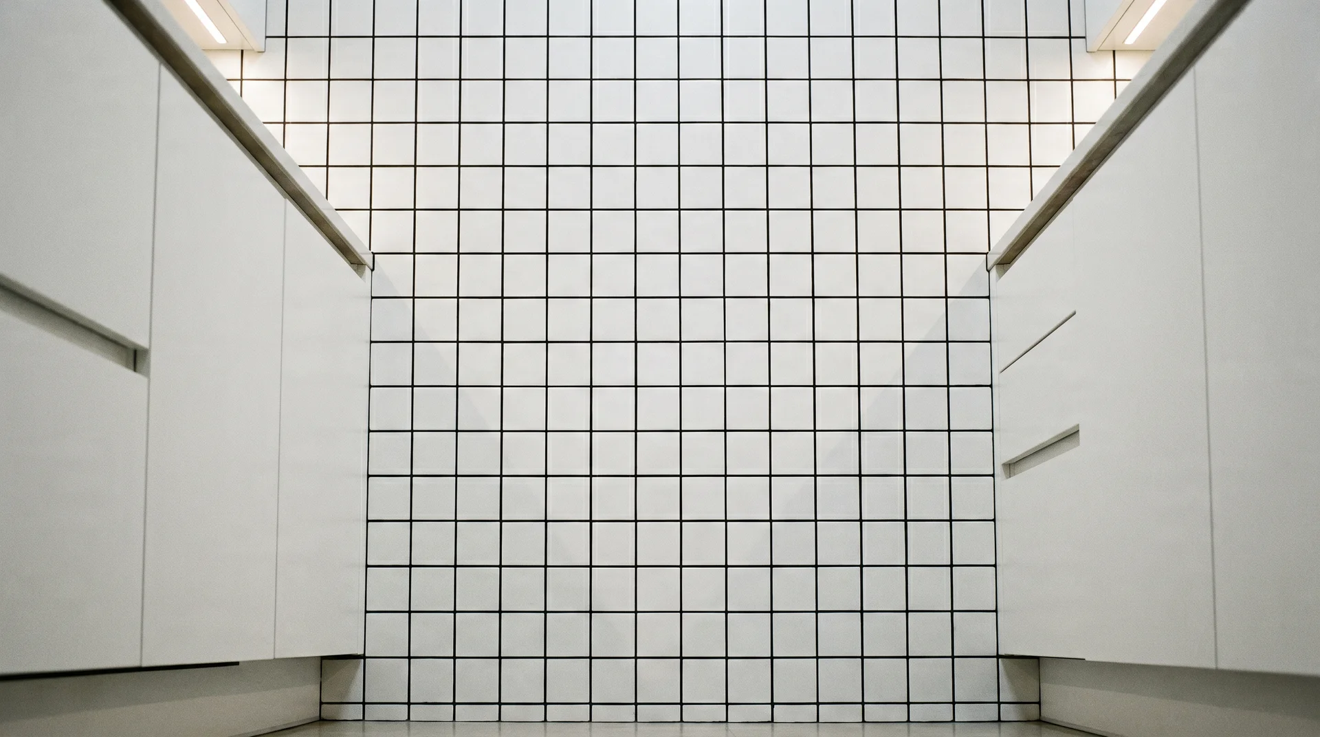 White tile stacked grid pattern with black grout, slab-front cabinets, precise grout lines in a contemporary kitchen