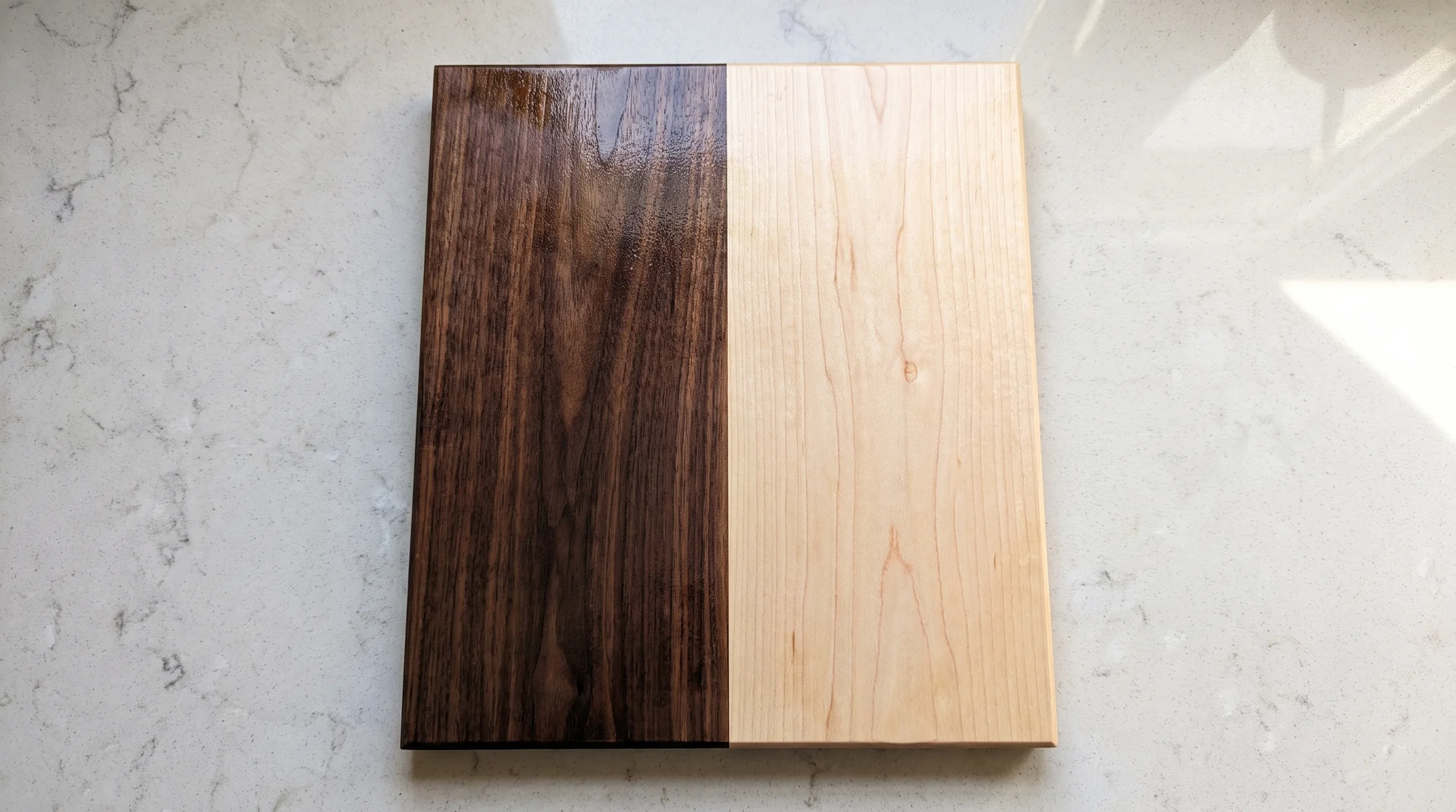 Wide two-plank cutting board with dark walnut and pale maple halves meeting at a single center glue line